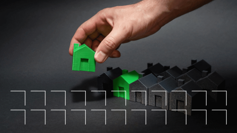 Hand placing a green model house apart from a row of identical dark houses, representing a property brand standing out in local search