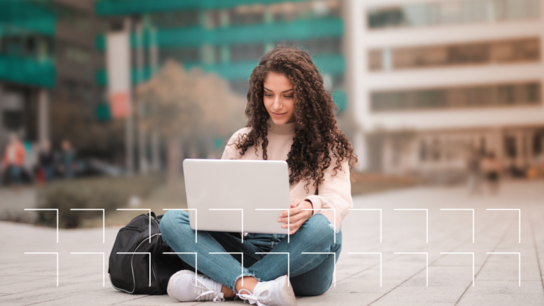 Woman sitting outdoors with a laptop, looking up how to find her Facebook URL
